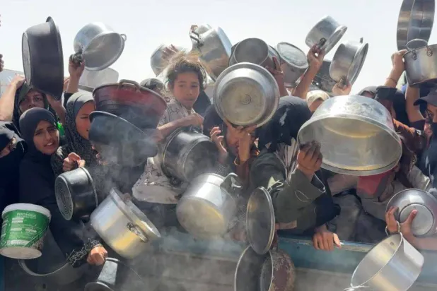 فلسطينيون يتدافعون للحصول على طعام من تكيَّة خيرية بمدينة غزة (الشرق الأوسط)