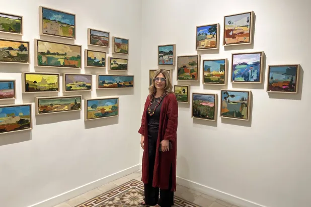 التشكيلية ليلى داغر أمام مجموعتها «لاند سكايب» (الشرق الأوسط)