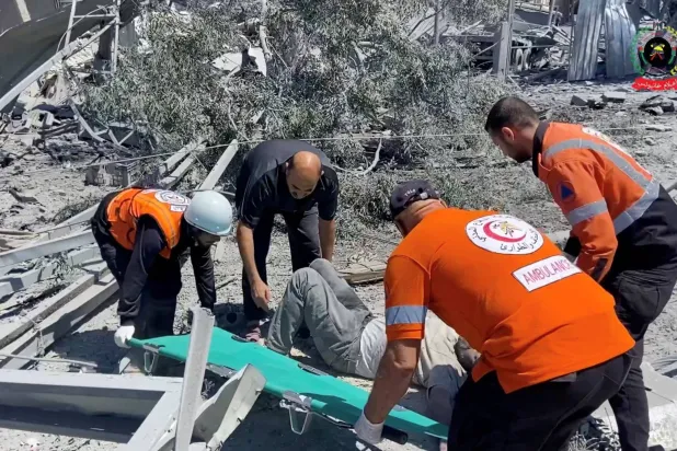 صورة أخذت من مقطع فيديو لرجال إنقاذ ينقلون مصاباً في خان يونس (رويترز)