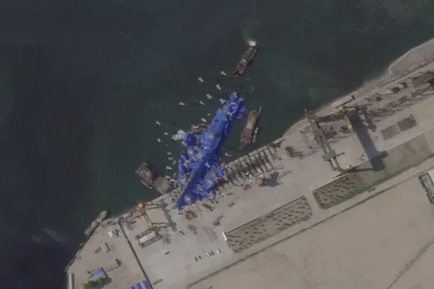 صورة بالأقمار الاصطناعية للسفينة الحربية الكورية الشمالية وقد جرى تغطيتها بعد حادث خلال تدشينها (رويترز) 