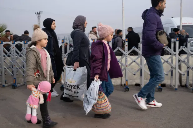 Beşşar Esed rejiminin devrilmesinin ardından 11 Aralık'ta Türkiye'deki Suriyeli mülteciler sınır kapısına doğru yürüyor (DPA)