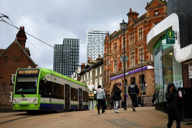 ناس يمشون على طول الشارع الرئيسي في كرويدون جنوب لندن (رويترز)