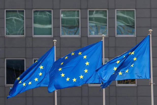 أعلام الاتحاد الأوروبي ترفرف خارج مقر المفوضية في بروكسل (رويترز) 