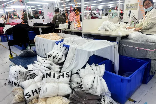 FILE PHOTO: Workers at a production line manufacturing clothing for Shein at a factory in Guangzhou, Guangdong province, China April 1, 2025. REUTERS/Casey Hall//File Photo