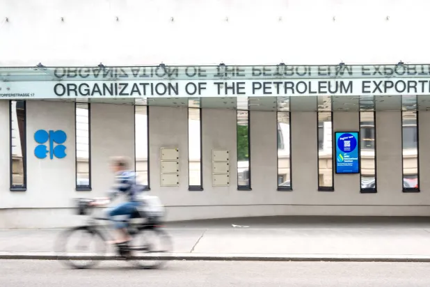 راكب دراجة يمرّ أمام مقرّ منظمة «أوبك» في فيينا (أ.ف.ب)
