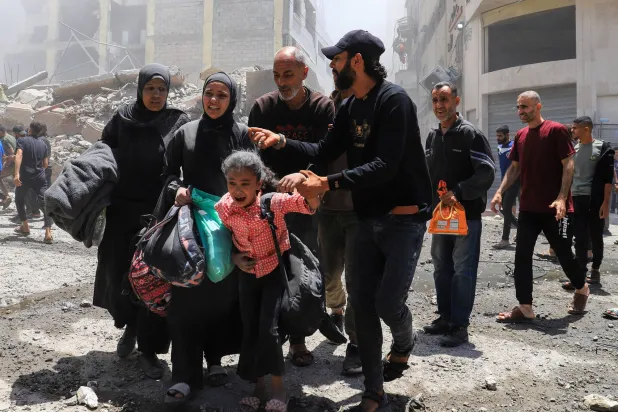 فلسطينيون يخلون موقعاً أصابته غارة إسرائيلية في قطاع غزة (رويترز)