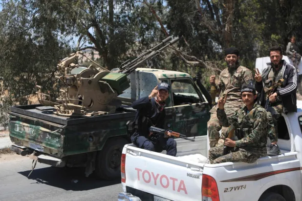 Başkent Şam'da zafer işareti yapan güvenlik güçleri, 29 Nisan 2025 (AFP)