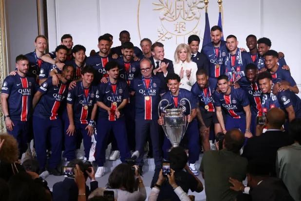 الرئيس الفرنسي وزوجته في لقطة جماعية مع الأبطال (رويترز)
