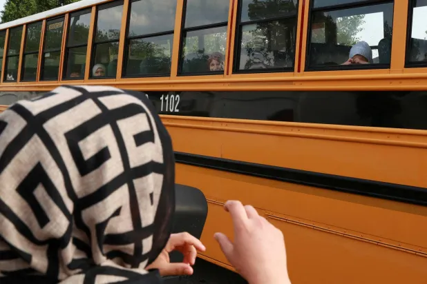  اللاجئة الأفغانية وحيدة حبيبي تُلوح بيدها لأطفالها في حافلة المدرسة في بولينغ غرين بولاية كنتاكي 30 أبريل 2025 ( رويترز) 