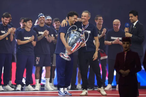 احتفالية لاعبي باريس سان جيرمان ومدربهم ورئيس النادي باللقب الأوروبي الأرفع (أ.ف.ب)