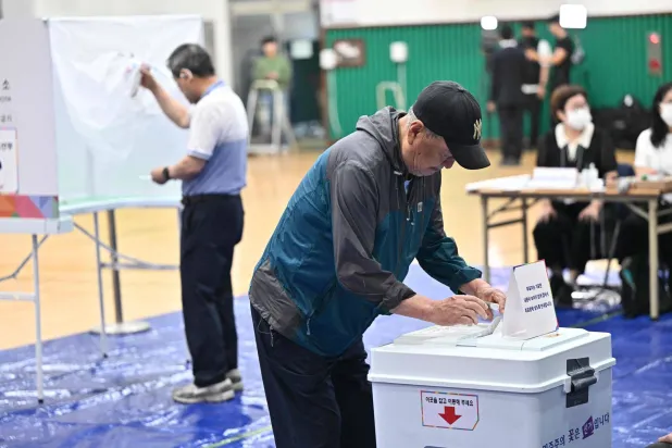 رجل يدلي بصوته بمركز اقتراع في سيول خلال انتخابات كوريا الجنوبية الرئاسية (أ.ف.ب)