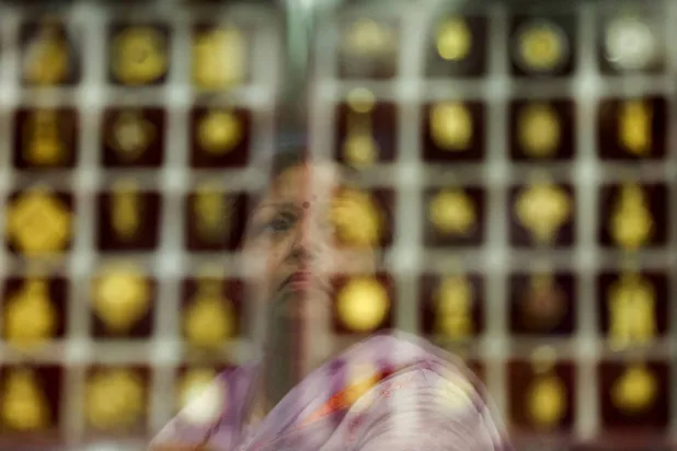 زبون يفحص حُلياً ذهبية في متجر مجوهرات في الأحياء القديمة بدلهي (رويترز)