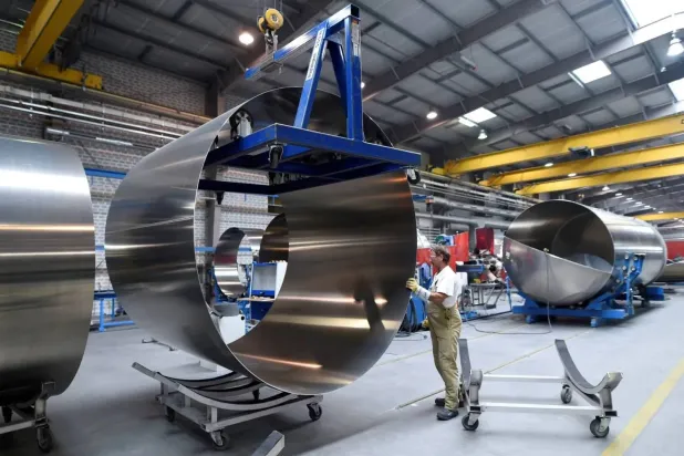 عامل في مصنع «فيلدبندر» الألماني ينقل لفائف الألمنيوم (أرشيفية - رويترز) 