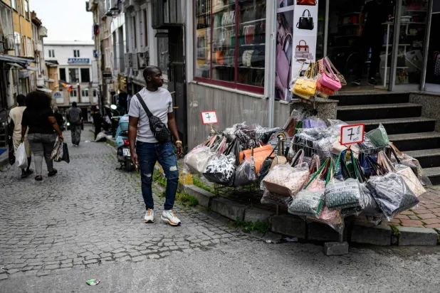 سائح يعاين أسعار الحقائب النسائية بمنطقة تجارية في إسطنبول (أ.ف.ب)