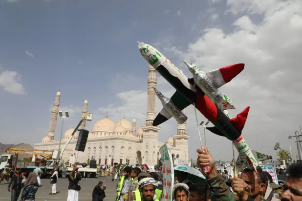 مناصرون للحوثيين يرددون شعارات ويحملون طائرة بدون طيار وهمية خلال احتجاج مناهض للولايات المتحدة وإسرائيل في صنعاء، 30 مايو 2025 (إ.ب.أ)