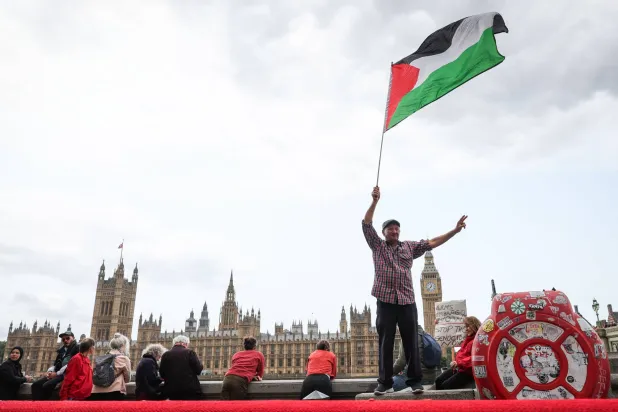 متظاهر يرفع العَلم الفلسطيني خلال مظاهرة مؤيدة للفلسطينيين أمام برج إليزابيث بلندن (أ.ف.ب)