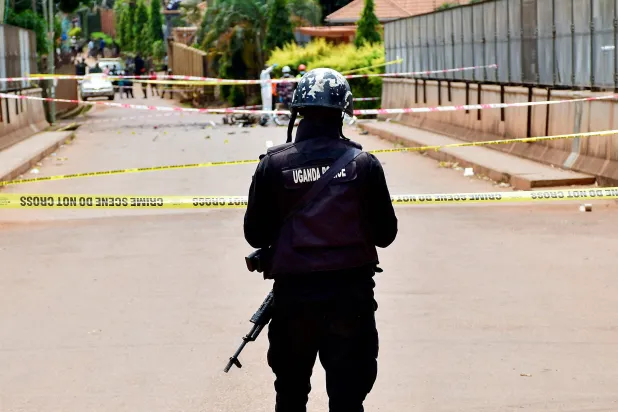 يقوم ضابط شرطة أوغندي بتأمين موقع انفجار قنبلة بالقرب من ضريح مونيونيو، وهو ضريح للكنيسة الكاثوليكية الرومانية، بينما كان الأوغنديون يتجمعون للاحتفال، الذي يُحيي ذكرى المسيحيين الذين قُتلوا بسبب إيمانهم في القرن التاسع عشر، في ضاحية مونيونيو في كامبالا، أوغندا (رويترز)