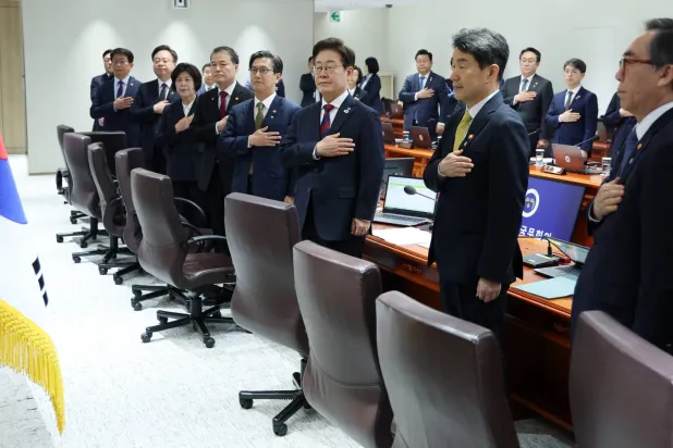 الرئيس الكوري الجنوبي لي جاي ميونغ يُحيي العلم خلال أول اجتماع وزاري بعد تنصيبه (د.ب.أ)