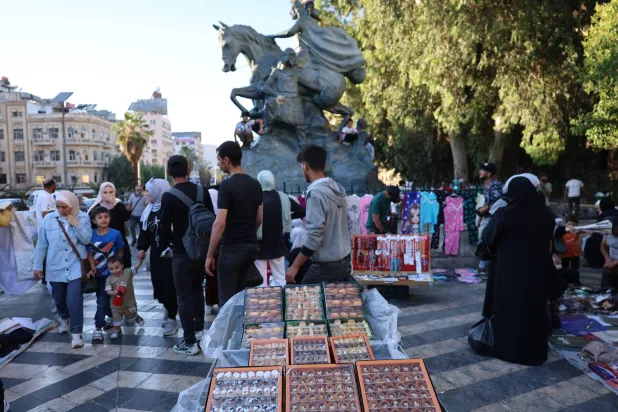 سلع متنوعة من حلويات وغيرها تباع على أرصفة دمشق (إ.ب.أ)