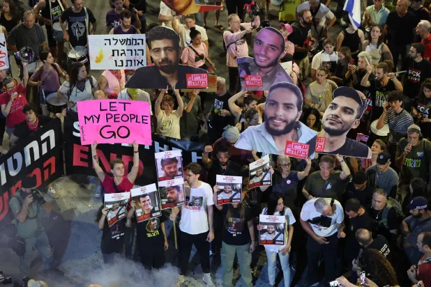 متظاهرون يحملون لافتات وصوراً للرهائن الإسرائيليين المحتجزين في قطاع غزة منذ هجوم 7 أكتوبر 2023 (أ.ف.ب)