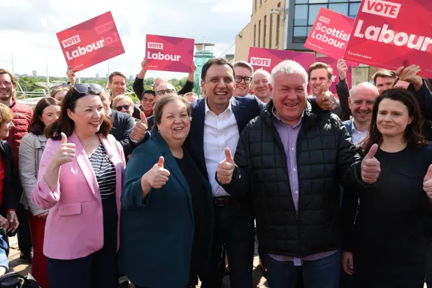 صورة ملتقَطة اليوم في إدنبره ببريطانيا تُظهر (الثاني من اليسار إلى اليمين) نائب زعيمة حزب العمال الأسكوتلندي جاكي بيلي وزعيم الحزب أنس ساروار والفائز بانتخابات البرلمان ديفي راسل خلال تجمع جماهيري في شارع كاسل بهاميلتون بعد إعلان راسل الفائز بالانتخابات الفرعية (د.ب.أ)