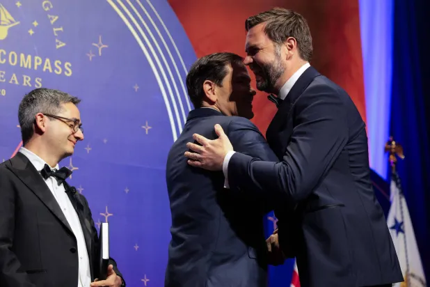 نائب الرئيس الأميركي يعانق وزير الخارجية وإلى جانبهما مؤسس «أميركان كومباس» خلال حفل في المتحف الوطني للبناء (أ.ف.ب)