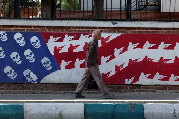 إيراني يمر أمام جدارية مناهضة للولايات المتحدة في أحد شوارع طهران (إ.ب.أ)