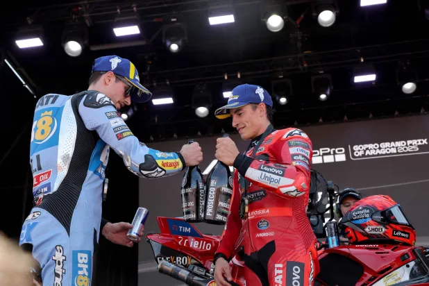 مارك ماركيز (يمين) يمزح مع شقيقه أليكس بعد فوزه عليه بسباق السرعة في خيريز (أ.ف.ب)