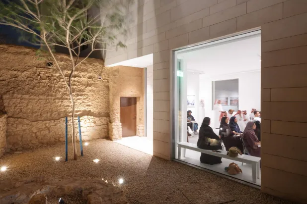 إضاءة ليلية تبرز التباين المعماري بين الطين والقاعات البيضاء في مركز شمالات الثقافي بالرياض (آغا خان للثقافة)
