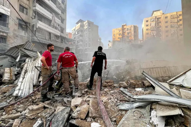 عناصر من الدفاع المدني في موقع استهداف إسرائيلي للضاحية الجنوبية الجمعة (أ.ف.ب)