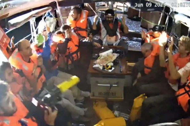 صورة نشرها «تحالف أسطول الحرية» تُظهر ناشطين على متن السفينة «مادلين» رافعين أيديهم بعد أن اعترضتهم القوات الإسرائيلية قبل وصولهم إلى الأراضي الفلسطينية المحاصرة (أ.ف.ب)