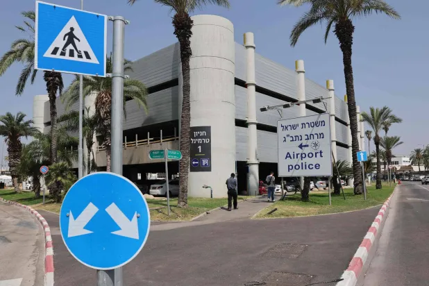 أشخاص يمرون أمام لافتة تشير إلى مركز للشرطة في مطار بن غوريون قرب تل أبيب (أ.ف.ب)