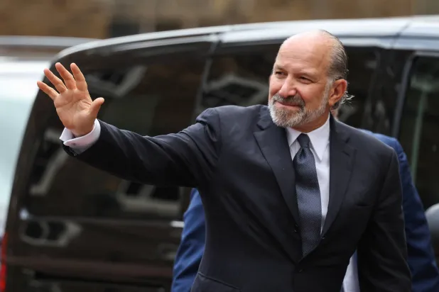 وزير التجارة الأميركي هوارد لوتنيك يلوح للصحافيين لدى وصوله إلى لانكستر هاوس «مقر انعقاد المباحثات مع الصين» في العاصمة البريطانية لندن (رويترز) 