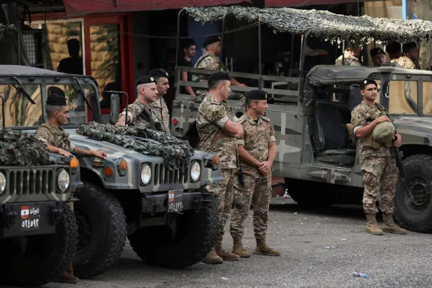 أفراد من الجيش اللبناني يقفون إلى جانب آليات عسكرية (رويترز)