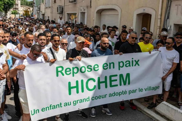 يحمل الحضور لافتة كُتب عليها «ارقد بسلام يا هشام طفلٌ ذو قلبٍ كبير تبنته القرية» خلال مشاركتهم في المسيرة البيضاء (Marche Blanche) في بوجيه سور أرجين (جنوب فرنسا) في 8 يونيو 2025 التي نُظمت تكريماً للحلاق التونسي هشام ميراوي بعد مقتله في 31 مايو وحمل الحضور لافتة كُتب عليها «ارقد بسلام يا هشام طفلٌ ذو قلبٍ كبير تبنته القرية» خلال مشاركتهم في المسيرة البيضاء في بوجيه سور أرجين (جنوب فرنسا) في 8 يونيو 2025 التي نُظمت تكريماً للحلاق التونسي هشام ميراوي بعد مقتله في 31 مايو (أ.ف.ب )