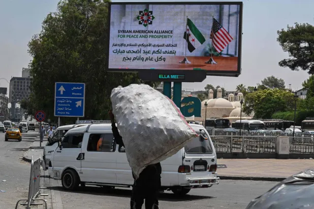 لافتة إعلانية من التحالف الأميركي - السوري على طريق رئيسي في دمشق تشكر الرئيس الأميركي دونالد ترمب (أ.ف.ب)