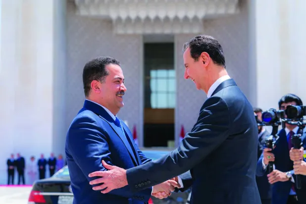 أرشيفية تجمع الرئيس السوري السابق بشار الأسد مصافحاً رئيس الوزراء العراقي محمد شياع السوداني في دمشق (إكس)