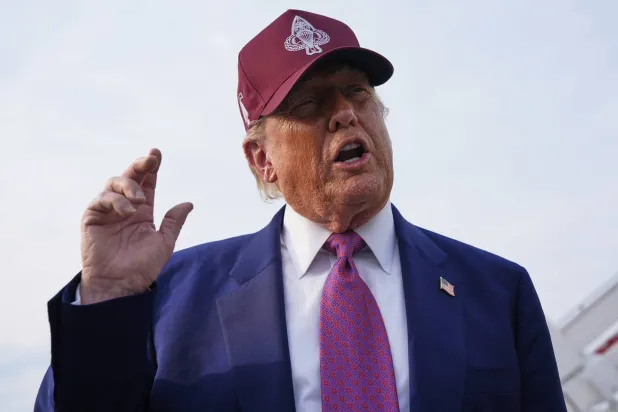 الرئيس دونالد ترمب يتحدث إلى صحافيين بعد وصوله على متن الطائرة الرئاسية إلى قاعدة أندروز الجوية مساء الثلاثاء (أ.ب)