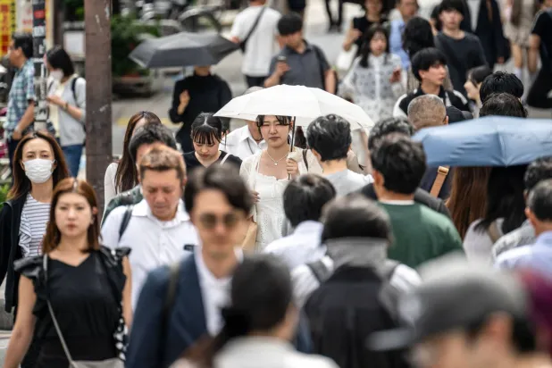 مشاة في شارع مزدحم وقت الذروة في وسط العاصمة اليابانية طوكيو (أ ف ب)