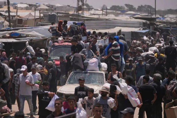 فلسطينيون يحملون أكياساً تحتوي على مساعدات غذائية قدمتها مؤسسة «غزة الإنسانية» (أ.ب)