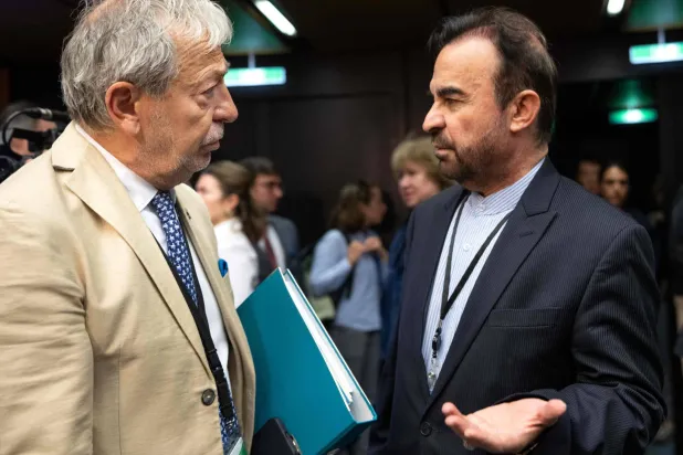 سفير إيران لدى المنظمات الدولية بفيينا رضا نجفي ومسيمو أبارو رئيس دائرة الضمانات بالوكالة الذرية على هامش اجتماع مجلس المحافظين الاثنين الماضي (أ.ف.ب)