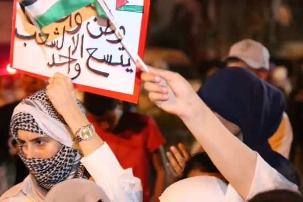 تونسيون يحملون لافتات مؤيدة للفلسطينيين يرحبون بـ«قافلة الصمود» في وقت سابق (أ.ف.ب)