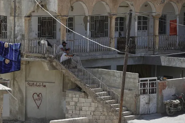 Residents sit outside their house in the Beit Jin village, southern Syria, where Israeli troops made a pre-dawn raid, arresting several alleged members of Hamas, Thursday, June 12, 2025. (AP)