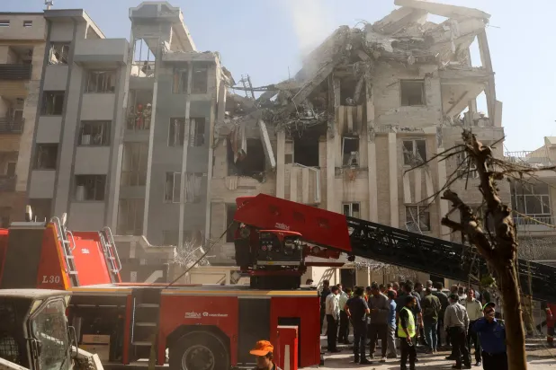 رجال الإنقاذ يعملون بموقع مبنى متضرر في أعقاب الغارات الإسرائيلية على طهران الجمعة (رويترز)