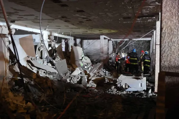 مسعفون إسرائيليون يتفقدون الأضرار داخل مبنى أصيب بصاروخ أُطلق من إيران قرب تل أبيب (أ.ف.ب)