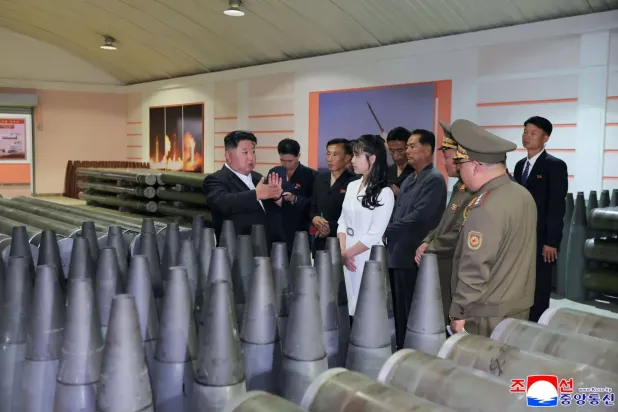 Kuzey Kore lideri Kim Jong Un (solda) kızıyla birlikte büyük bir mühimmat fabrikasını denetliyor (AFP)