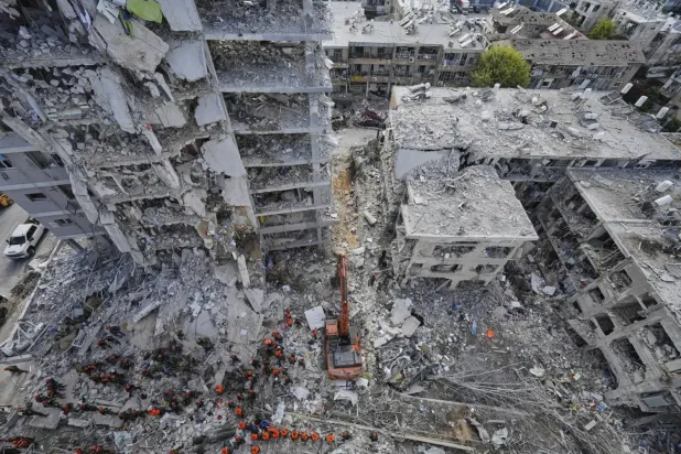 Tel Aviv'in güneyindeki Bat Yam'da dün İran'ın füze saldırısı sonucu yıkılan konutların enkazı altında kayıp kişileri arayan İsrail askerleri (AP)