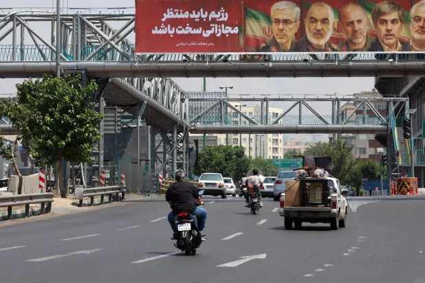 لوحة تحمل صوراً لكبار القادة الإيرانيين الذين قتلوا جراء الهجمات الإسرائيلية فجر الجمعة الماضي (إ.ب.أ) 