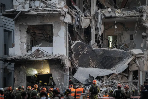 آثار الدمار في أحد المواقع بتل أبيب (إ.ب.أ)