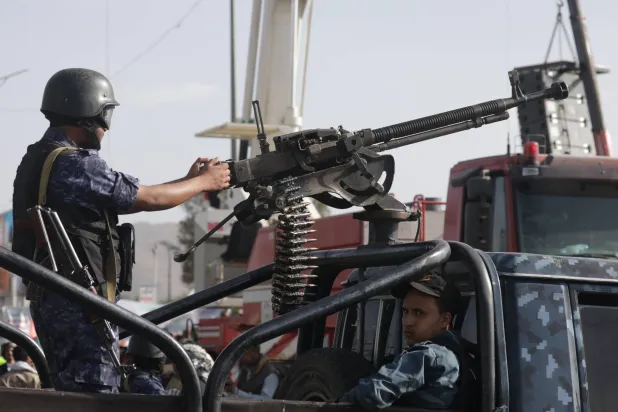 عنصر حوثي يمسك رشاشاً ثقيلاً على متن عربة عسكرية في صنعاء (إ.ب.أ)